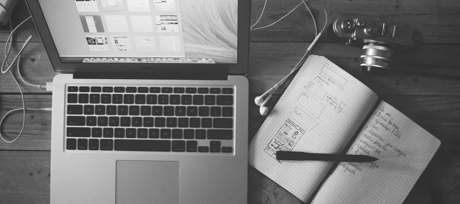 Laptop next to a notebook with hand-drawn sketches
